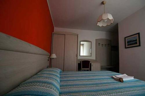 佩尔吉内瓦尔苏加纳Albergo Mezzolago的一间卧室配有一张带蓝色条纹毯子的床