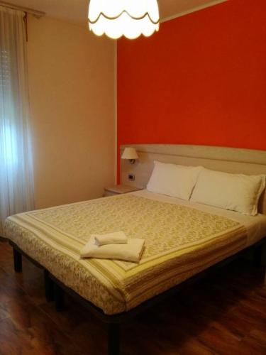佩尔吉内瓦尔苏加纳Albergo Mezzolago的一间卧室设有一张红色墙壁的大床