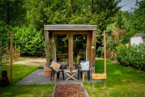迪森Tiny House Hilver - uniek en sfeervol huisje middenin het bos的庭院内带桌椅的凉亭