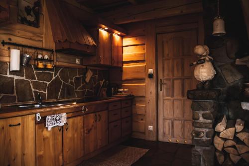 克雷尼察Chaty Wichrowe Wzgórze的厨房配有木制橱柜和石墙