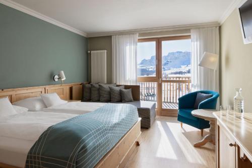 阿尔卑斯休斯山ICARO Hotel的酒店客房,配有床和沙发