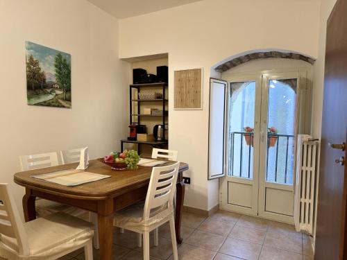 Santa Maria del MoliseB&B I Mulini的一间带木桌和白色椅子的用餐室