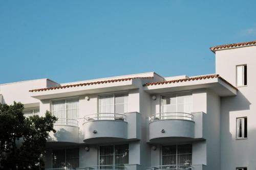 卡拉纳雅达Prinsotel La Pineda的带阳台的建筑和蓝天