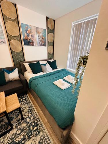 伯明翰R2 - Newly renovated Luxury Private En-Suite Room in Harborne Park Road - Birmingham的一间卧室配有一张带绿色床单的床和一张沙发