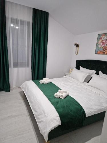 蒂米什瓦拉Gold Tag Apartament的一间卧室配有一张大床和毛巾