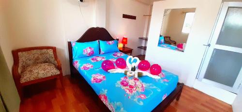阿约拉港HISTORICO HOSTAL ELIZABETH的一间卧室配有一张蓝色的床,上面有帽子