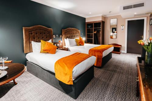 都柏林特鲁里科特酒店的酒店客房设有两张床和一张桌子。