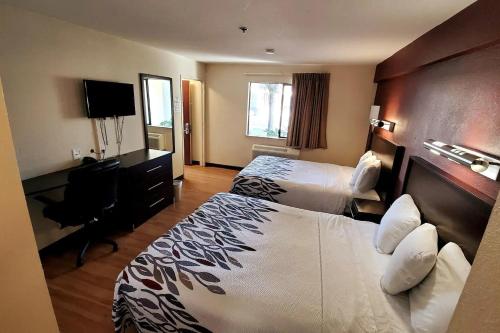 萨克拉门托Sacramento Inn & Suites的酒店客房配有两张床和一张书桌