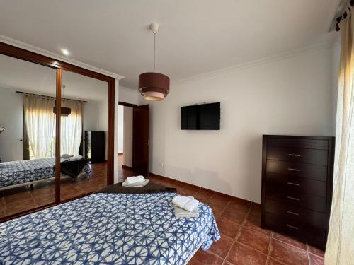 格拉纳迪利亚德亚沃纳Alquilaencanarias Sotavento Paradise的一间卧室配有一张床、梳妆台和镜子
