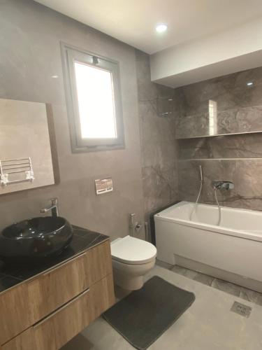 乌姆苏克Villa Oasis Djerba的一间带水槽和卫生间的浴室以及窗户。