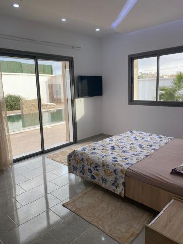 乌姆苏克Villa Oasis Djerba的一间卧室设有一张床和一个大窗户