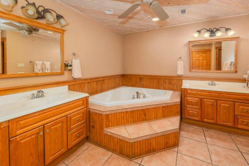 弗雷德里克斯堡Country Inn Cottages的浴室设有2个水槽、浴缸和镜子