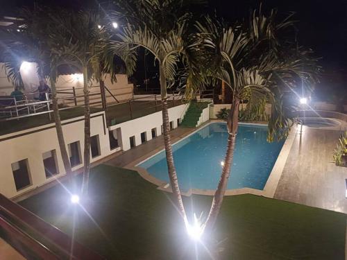 昆卡Casa de campo Country house in Yunguilla, Cuenca, Ecuador的棕榈树和灯光的夜间游泳池