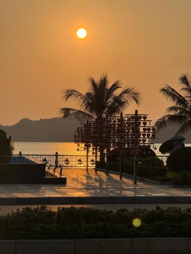 吉婆岛Phoenix Flower Hotel的棕榈树海滩上的日落和海洋
