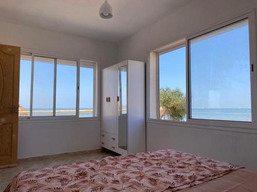 MouamlaBeach houses Lost paradise的卧室设有窗户和1张享有海景的床。