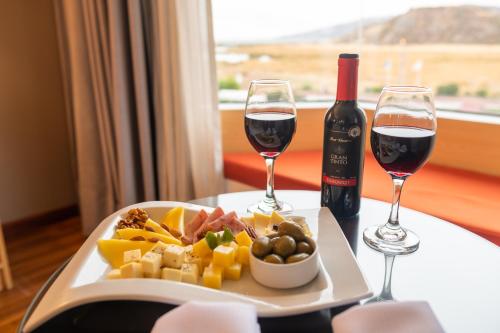 普诺Lake Titicaca Hotel的盘子和两杯葡萄酒