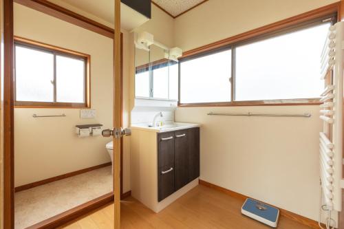 野沢Vaisala的一间带水槽和卫生间的浴室以及窗户。