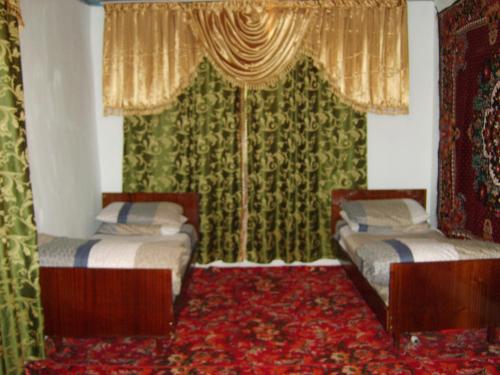 Yukary-UkhumShiringul guesthouse in nuratau mountain的红地毯间内的两张床