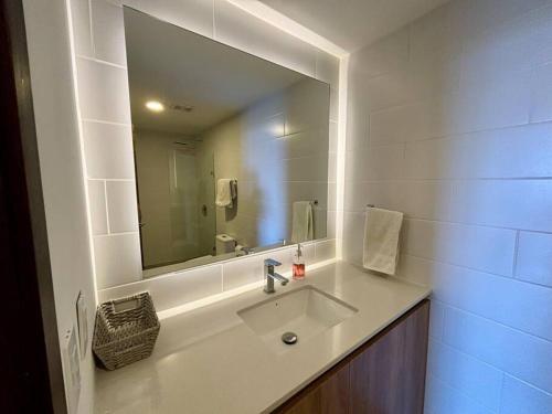 危地马拉Tropical Apartment in the city的一间带水槽和大镜子的浴室