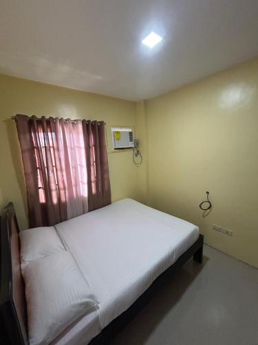 OroquietaAlmar Apartelle的一间小卧室,配有白色的床和窗户