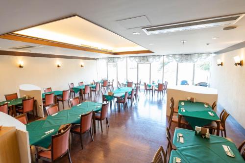 富士宫市Kyukamura Fuji的用餐室配有绿色的桌椅