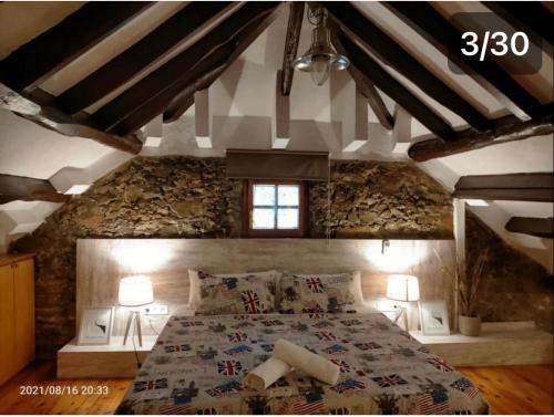 巴达洛纳Casa Flores del Mediterráneo的卧室配有一张石墙内的大床