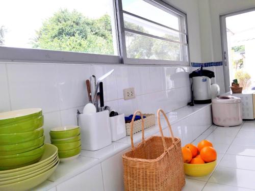 盼武里บ้านพิม的一个带碗盘的厨房台和窗户