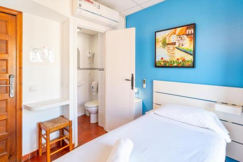 塔拉戈纳塔拉戈纳论坛旅馆的卧室配有白色的床和蓝色的墙壁