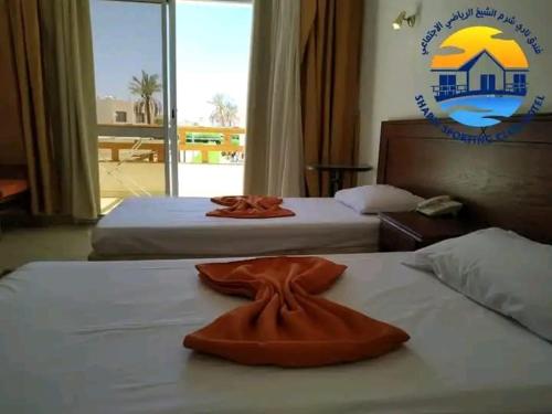 沙姆沙伊赫Club Marine Residence的酒店客房,配有两张带毛巾的床