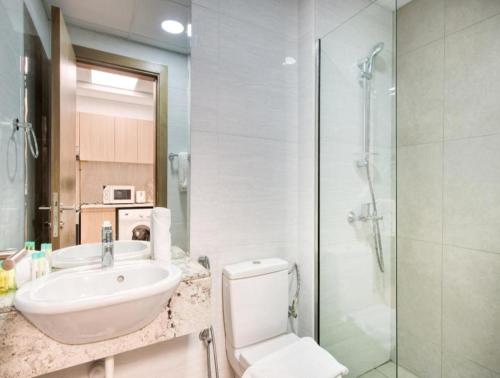 迪拜Gorgeous Posh Studio Apartment的浴室配有卫生间、盥洗盆和淋浴。