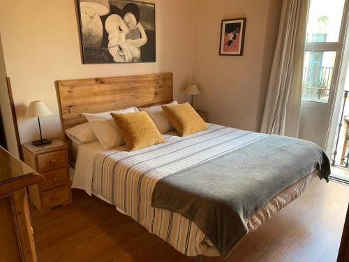 塞维利亚VIVIENDA SAN AGUSTÍN的一间卧室配有一张带黄色枕头的大床