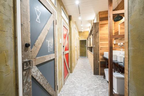 琴平町Kotori Coworking & Hostel Kotohira的走廊上设有带水槽的浴室和门