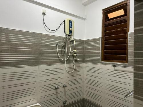 亭可马里Trinco Waves的带淋浴的浴室(墙上配有吹风机)