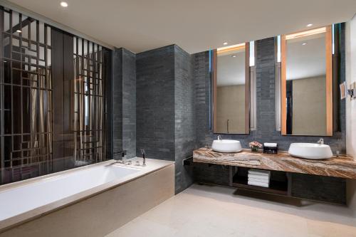 重庆重庆保利花园皇冠假日酒店的浴室配有两个盥洗盆和浴缸。