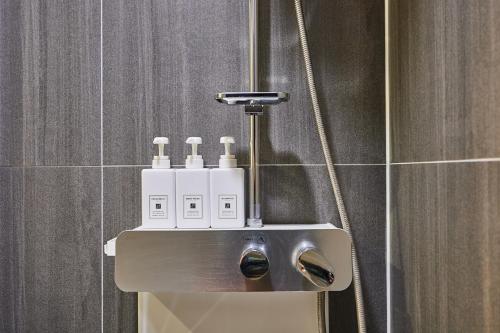 Urban Hotel的带淋浴的浴室,配有肥皂喷雾器