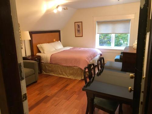 温哥华Vancouver guest house的卧室配有床、椅子和窗户。