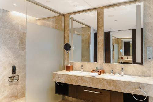 黄岛青岛西海岸隆和福朋喜来登酒店的一间带两个盥洗盆和大镜子的浴室