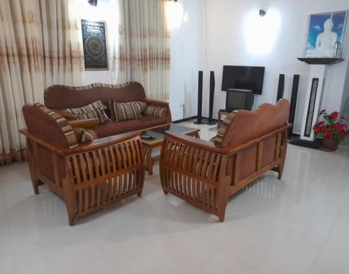 高尔JANA HOUSE的客厅配有两张沙发和一台电视机