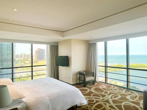 黄岛青岛西海岸隆和福朋喜来登酒店的酒店客房设有一张床,享有海景。