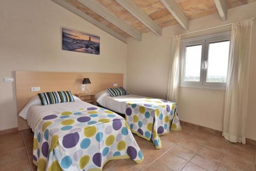 锡内乌Sa Tanca Gran的一间卧室设有两张床和窗户。