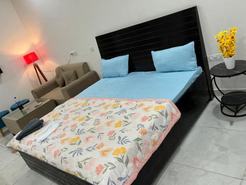 诺伊达Meadow suites ! Comfortable stay的一间卧室配有一张带蓝色棉被的床