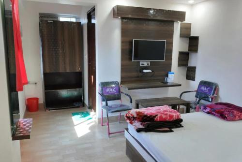 巴特那Goroomgo Mayagiri Patna的一间卧室配有两张床、一张桌子和两把椅子