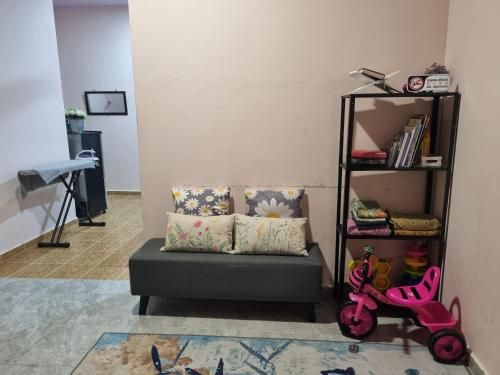甘榜甘马挽Umar's Tiny House的客厅配有沙发和带书籍的书架