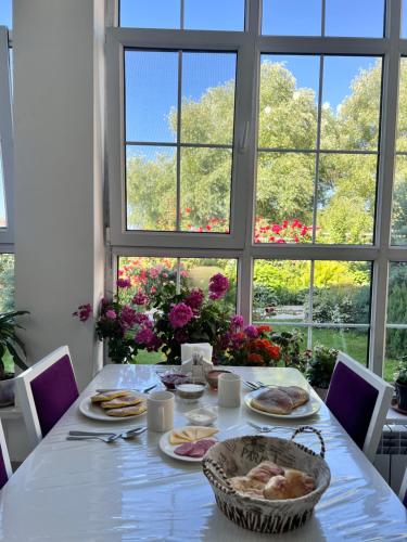 Bulan SogottuuГостевой дом Дастан, Guest House Dastan的餐桌,餐桌上放着盘子和窗户