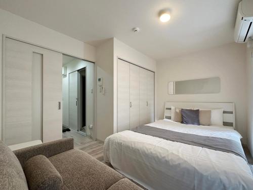 尾道市bHOTEL Yutori - Homestyle 1BR Apartment in Onomichi for 3 Ppl的一间卧室配有一张床和一张沙发