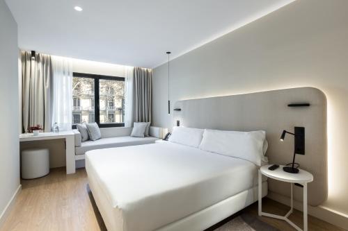 巴塞罗那皇家大道酒店的白色卧室设有一张大床和一张沙发