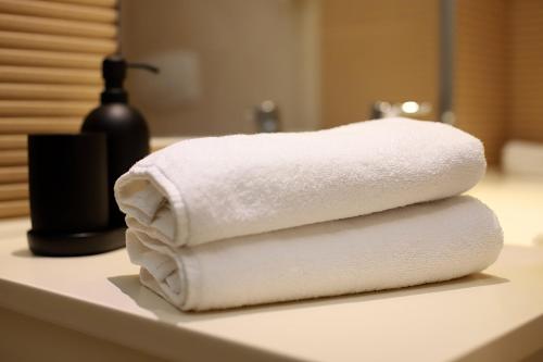 布加勒斯特Onix Rin Grand Apartment的浴室内台面上的毛巾堆