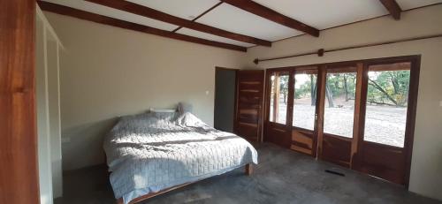 Adansonia Farm的一间卧室设有一张床和一个滑动玻璃门
