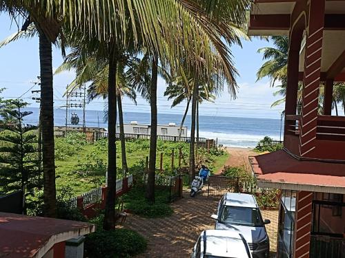 波戈马洛LEON HOME STAY的棕榈树房屋享有海滩美景