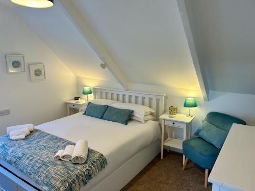 福伊Fowey River Views的卧室配有白色的床和蓝色椅子